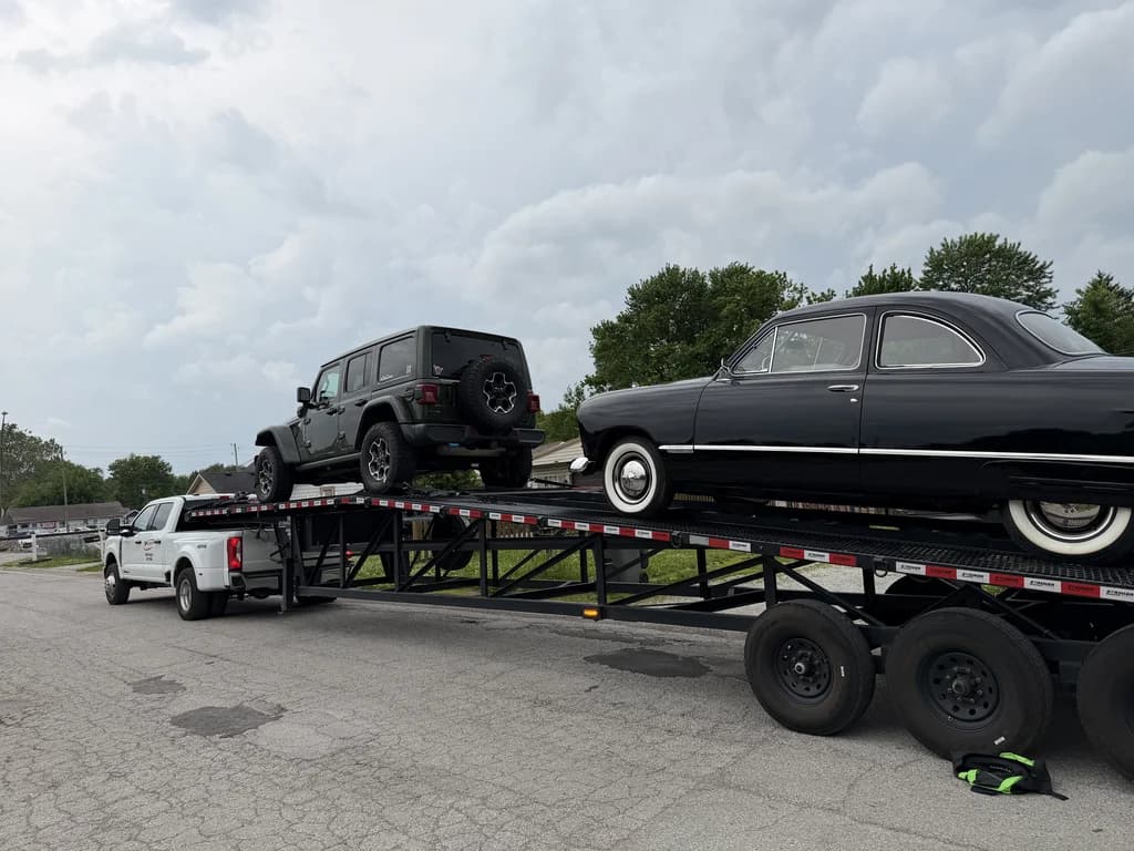 Velocity Logistics wedge carrier loaded with a Jeep and a classic car for door-to-door delivery