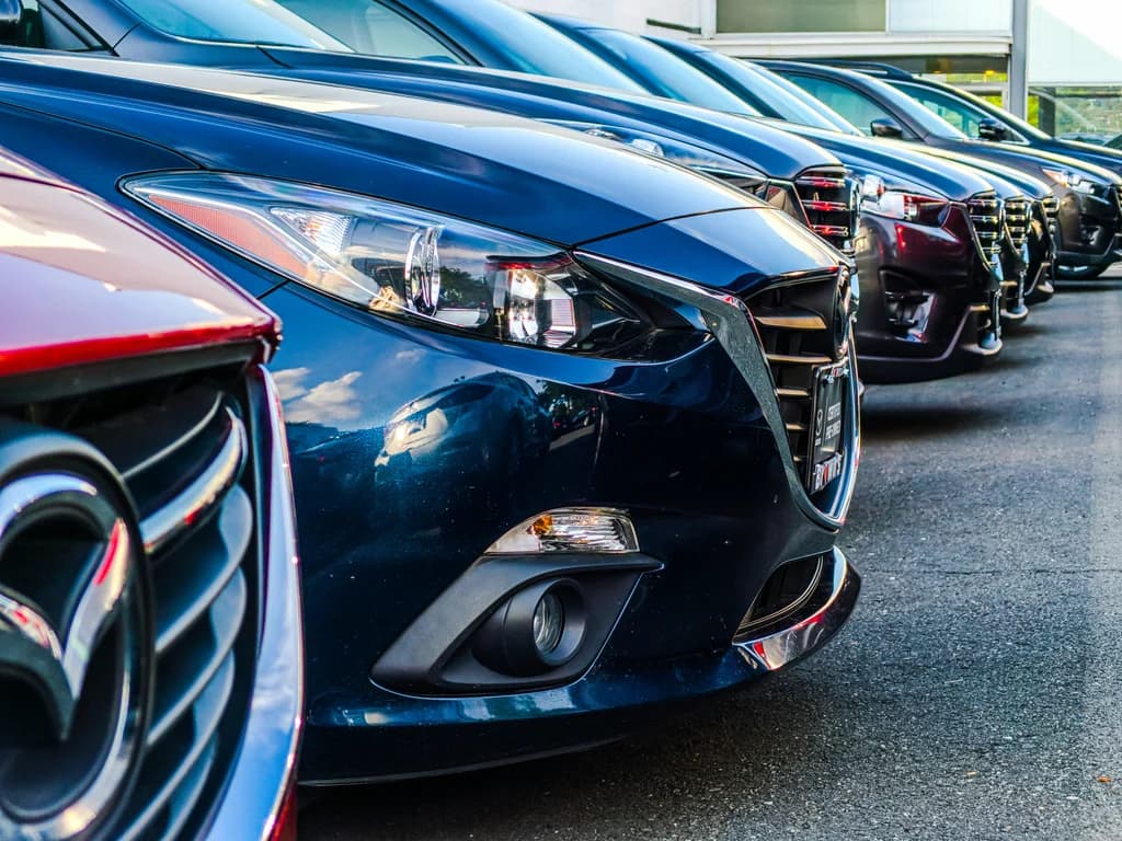 A row of new cars parked on a dealer lot