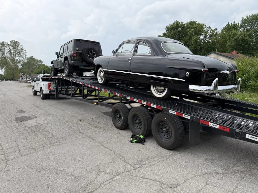 A classic car and a Jeep secured on a Velocity Logistics wedge carrier