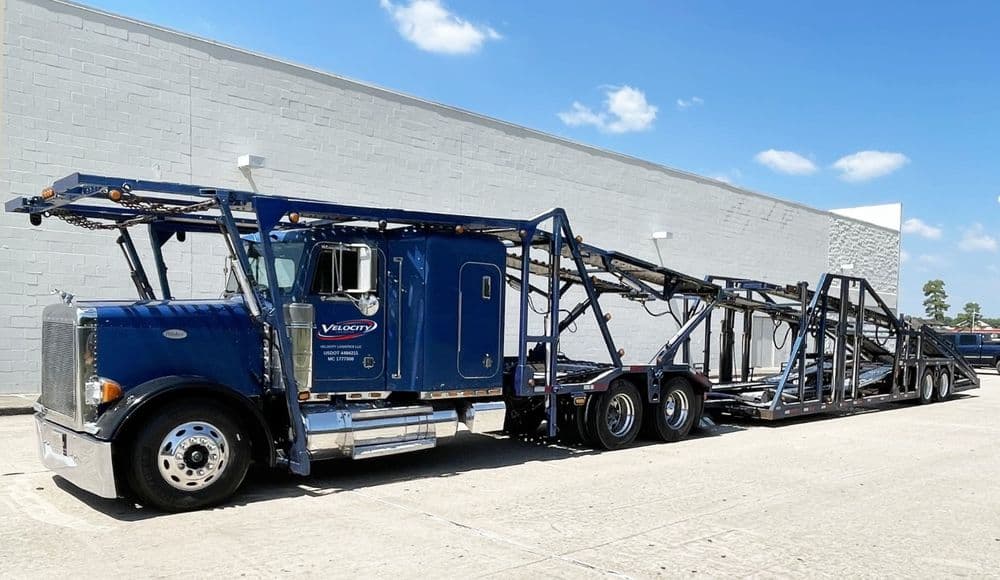 Velocity Logistics semi with a 7-car hauler trailer, logo and USDOT number on the cab