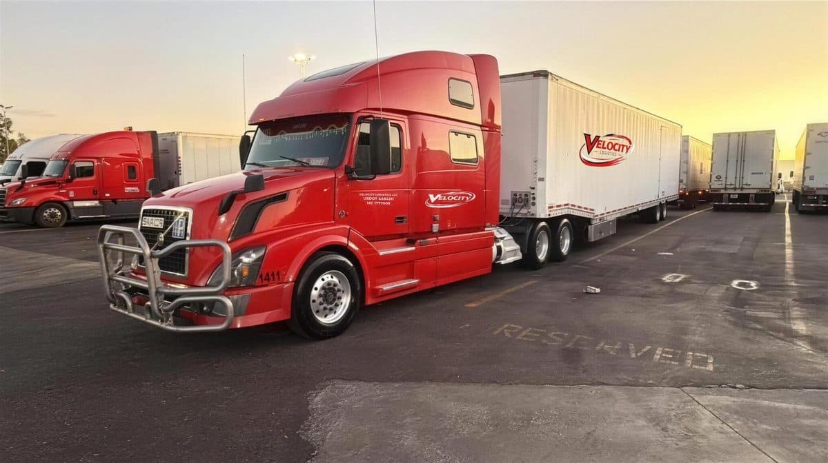 Velocity Logistics Volvo semi with a car trailer